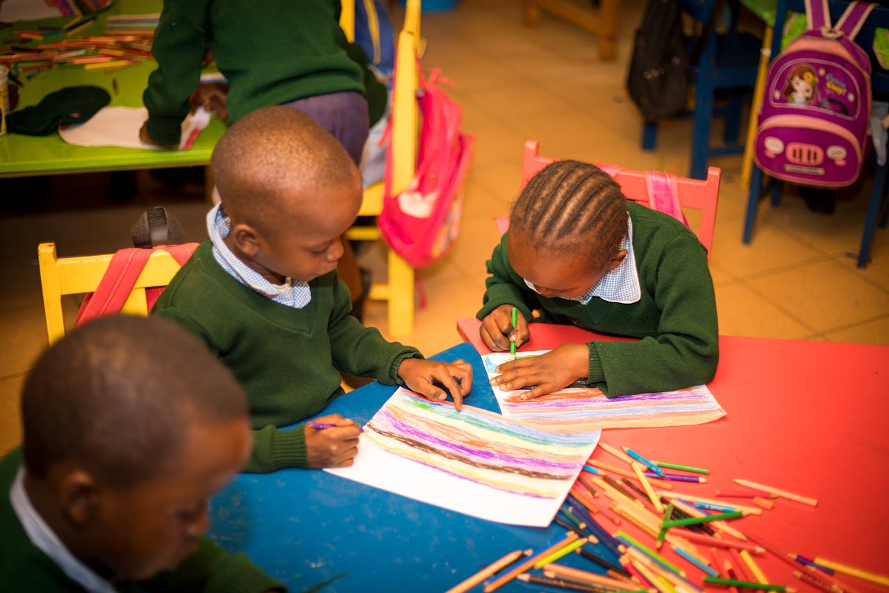 Young children engaged in colorful drawing activities at school, fostering creativity and teamwork.